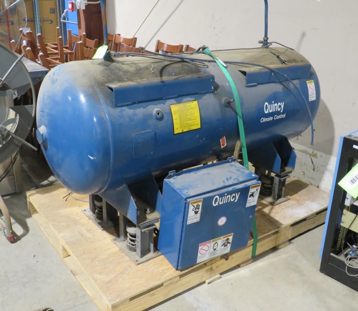 Blue Quincy air compressor on a wooden pallet.