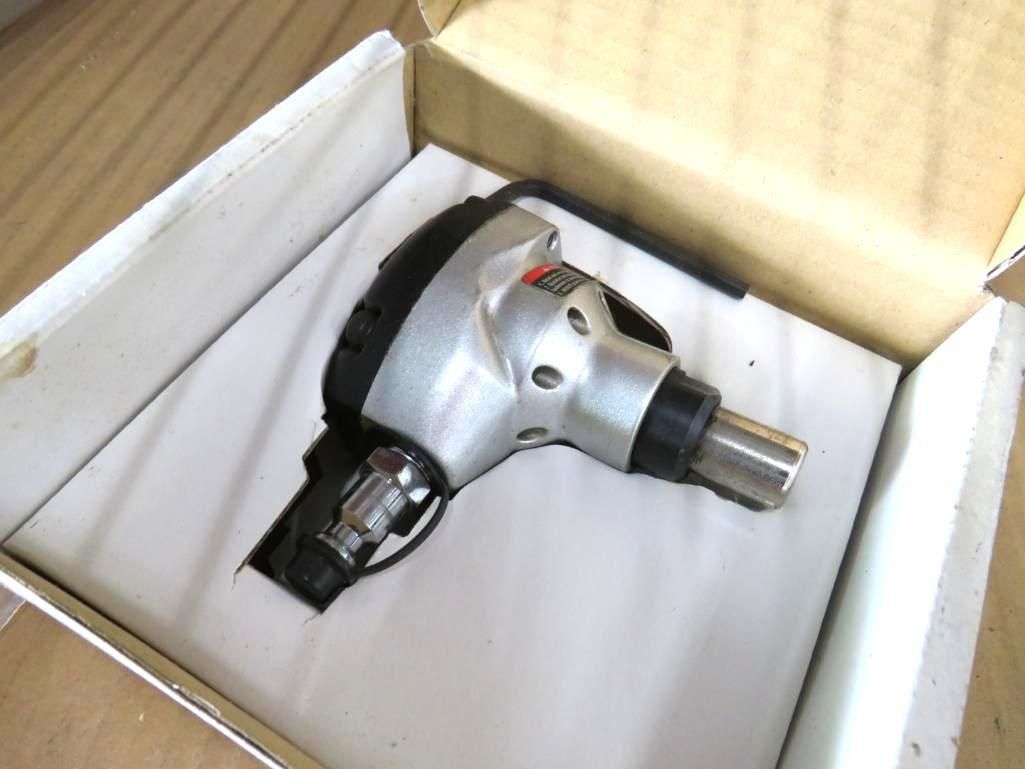 Pneumatic tool in a cardboard box with white padding.