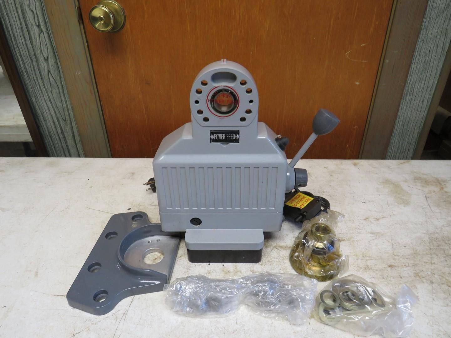 Gray metal work head with lever, additional parts on a wooden surface.