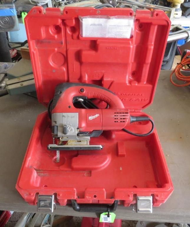 Red Milwaukee jigsaw in open red carrying case on a table.