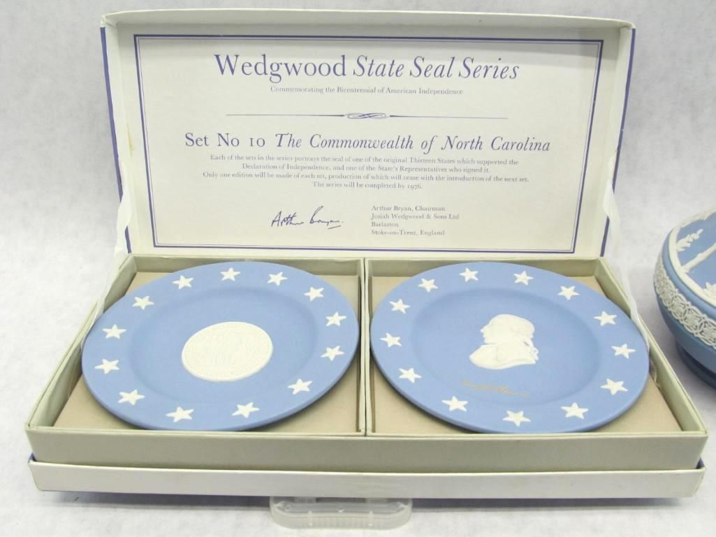 Two Wedgwood blue plates in a box with white stars, featuring a state seal.