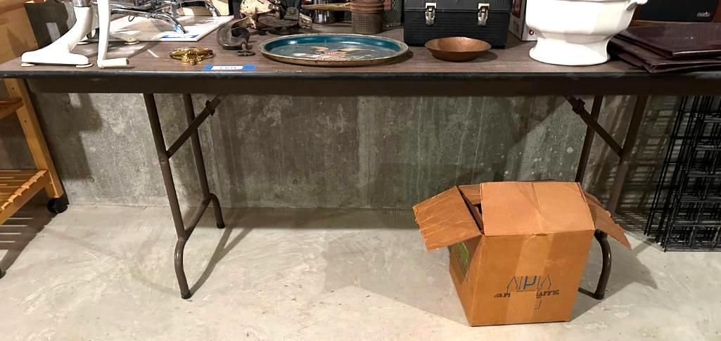 A long, brown folding table with items on top.
