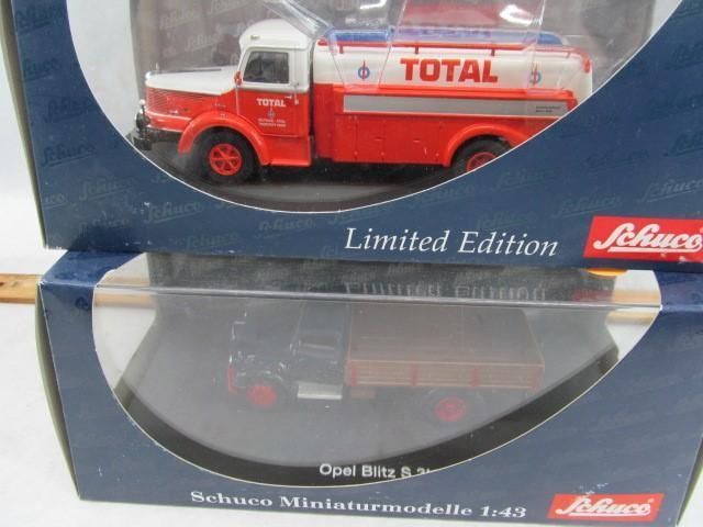 Two boxed model trucks: a red Total tanker and a blue Opel Blitz & Son cargo truck.