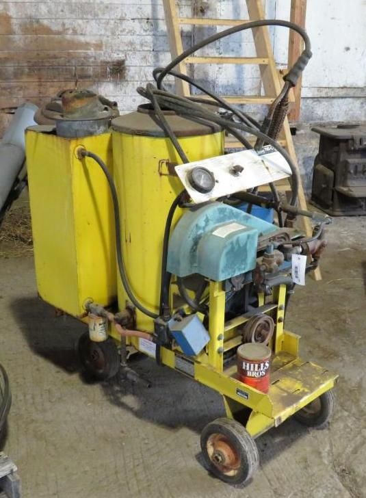 Yellow and blue road striping machine on wheels.