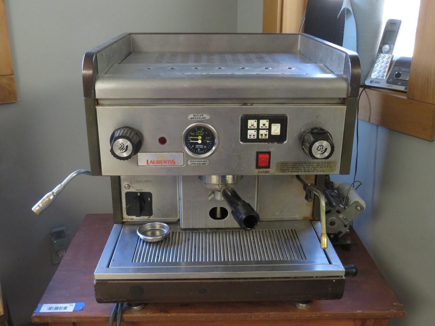 Espresso machine with dials, buttons, and a steam wand. Silver with a black handle.