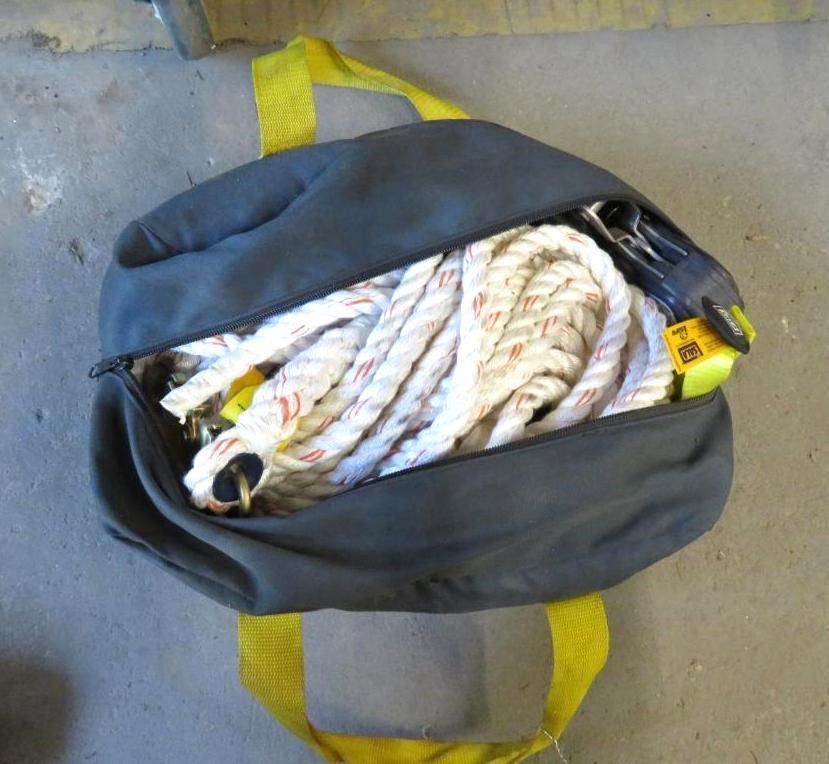 Black bag with yellow straps, open to reveal coiled white rope and a yellow and black object.