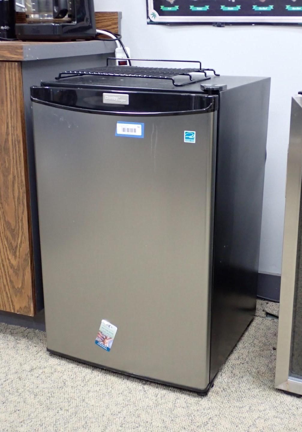 Small silver mini-fridge against a wall in an office setting.