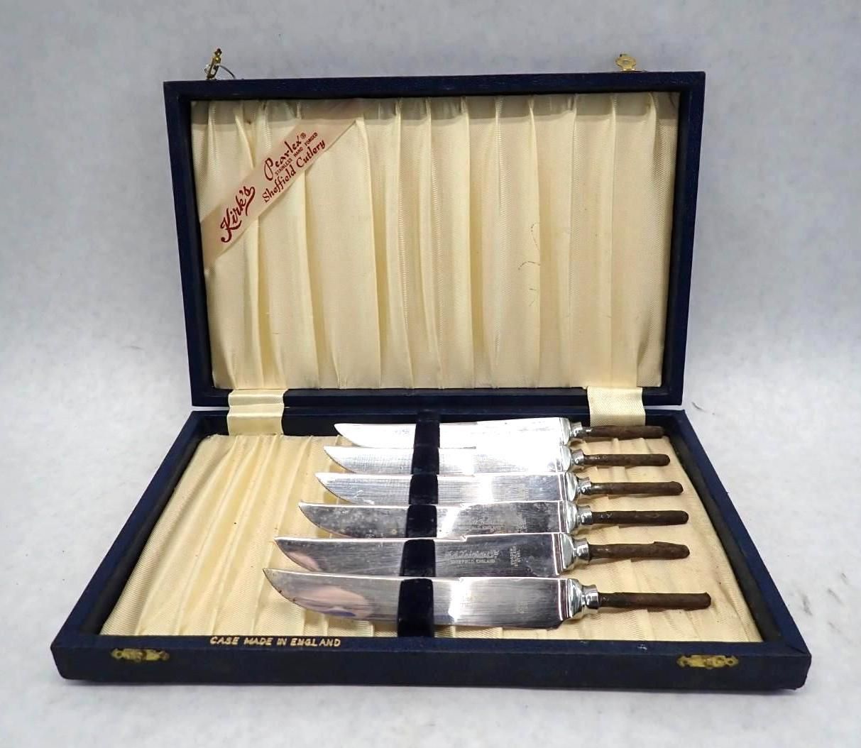 Set of six knives in a blue velvet-lined box with ivory fabric.