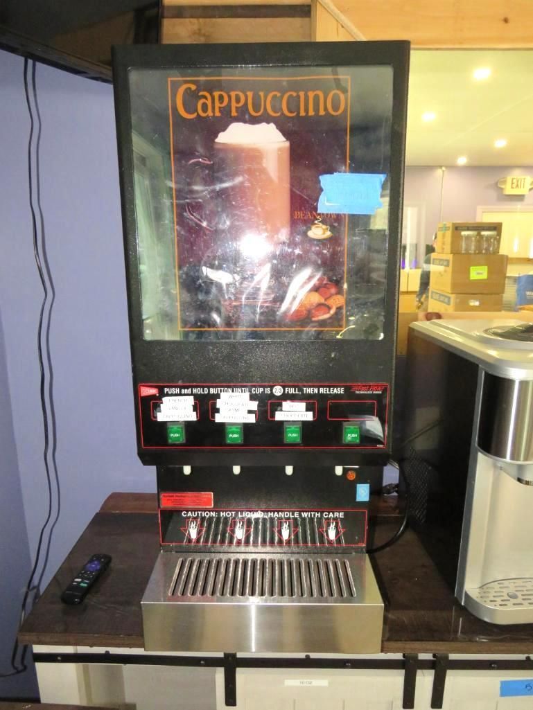 Cappuccino machine on a counter; black and stainless steel with drink options displayed.