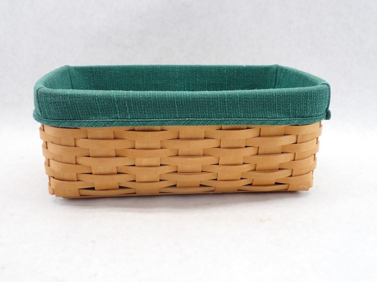 Woven basket with a green fabric lining against a white background.