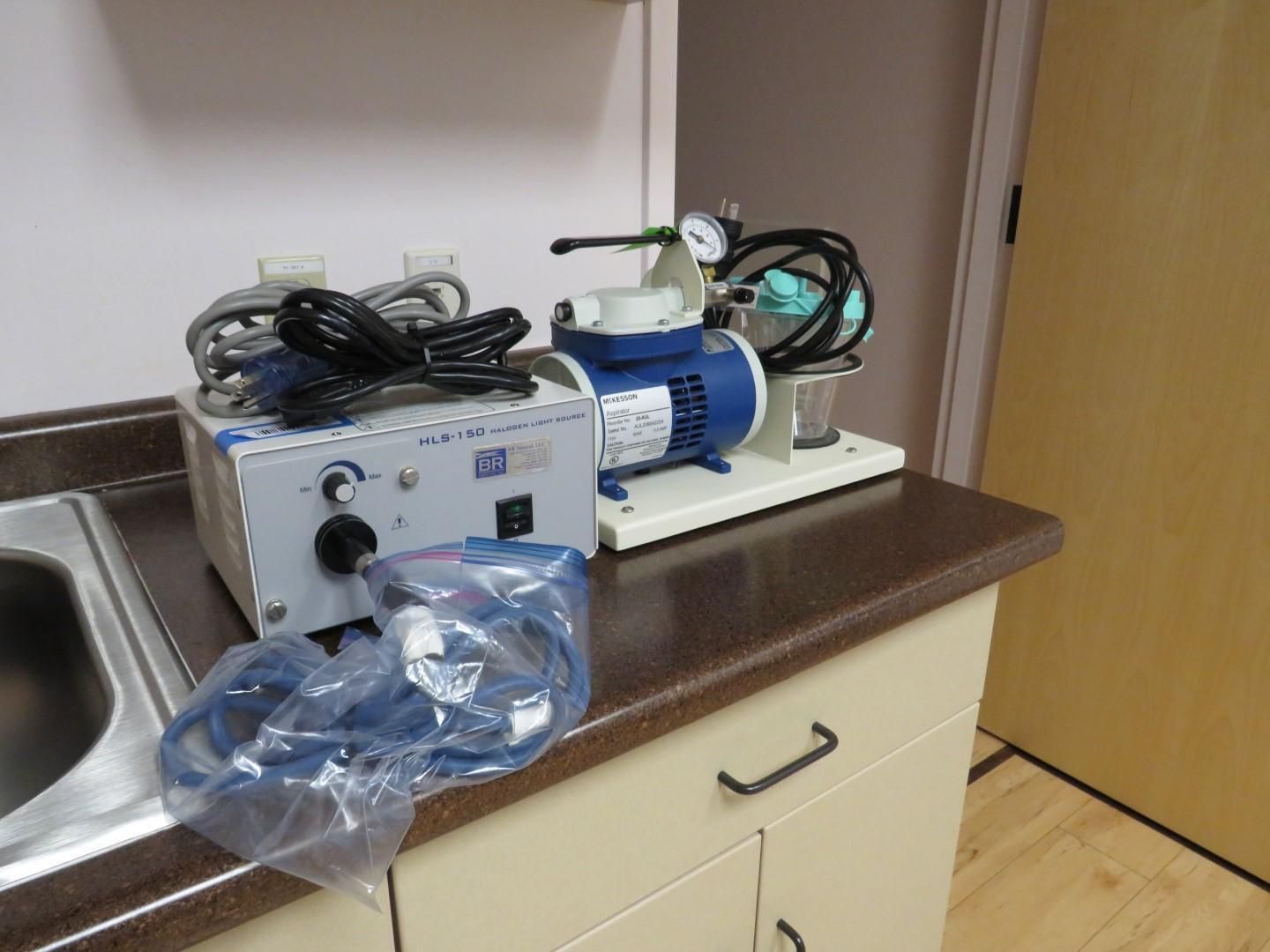 Nebulizer and oxygen tank setup on a countertop in a medical setting, with blue and white equipment.