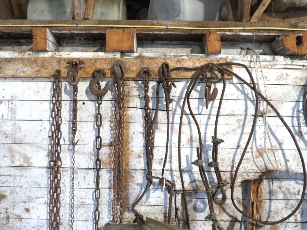 Chains and tools hanging on a wooden wall.