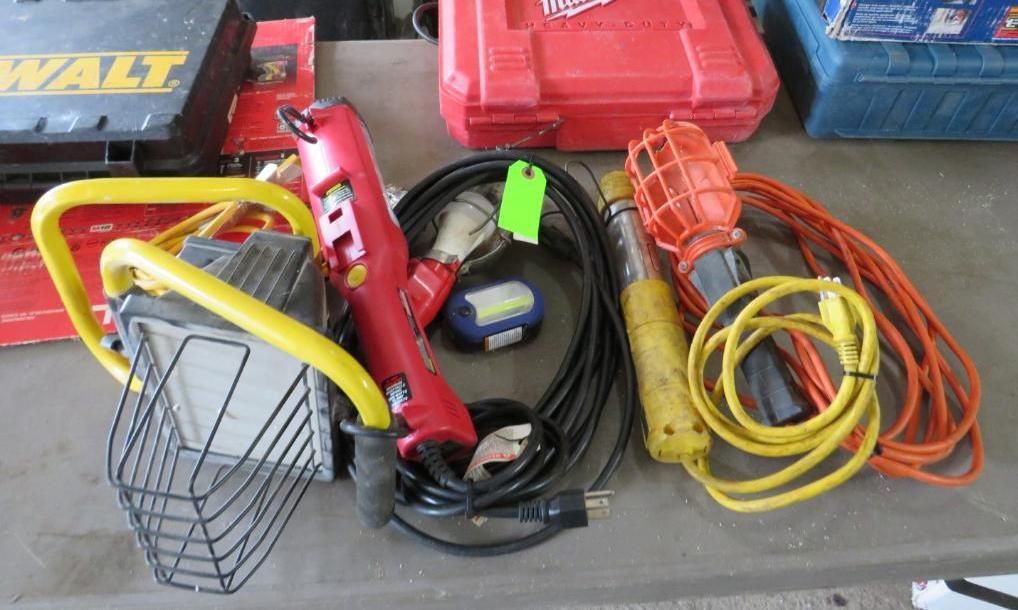 Assortment of work lights, power tools, and cords on a table.