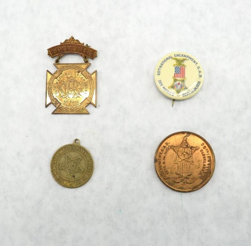 Four antique metal pins: Cross-shaped, button, circular medal, and round medal.