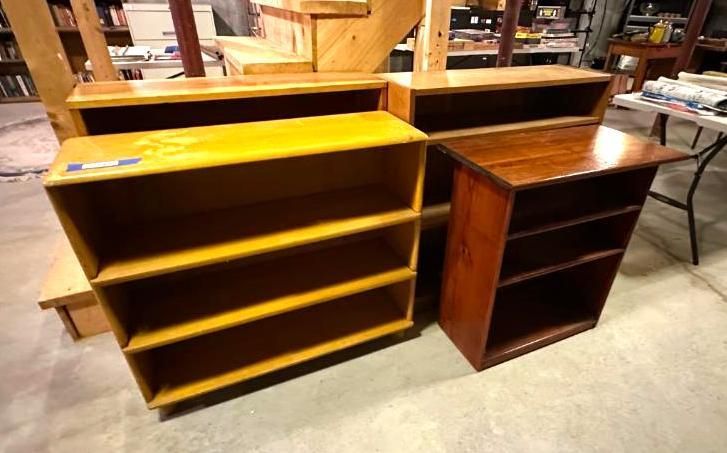 Four wooden bookshelves of various sizes and colors.