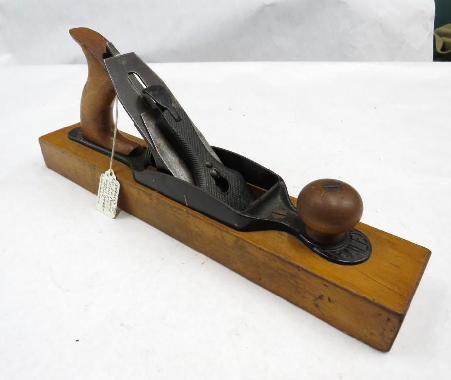 Wooden hand plane with a dark iron blade and handle.