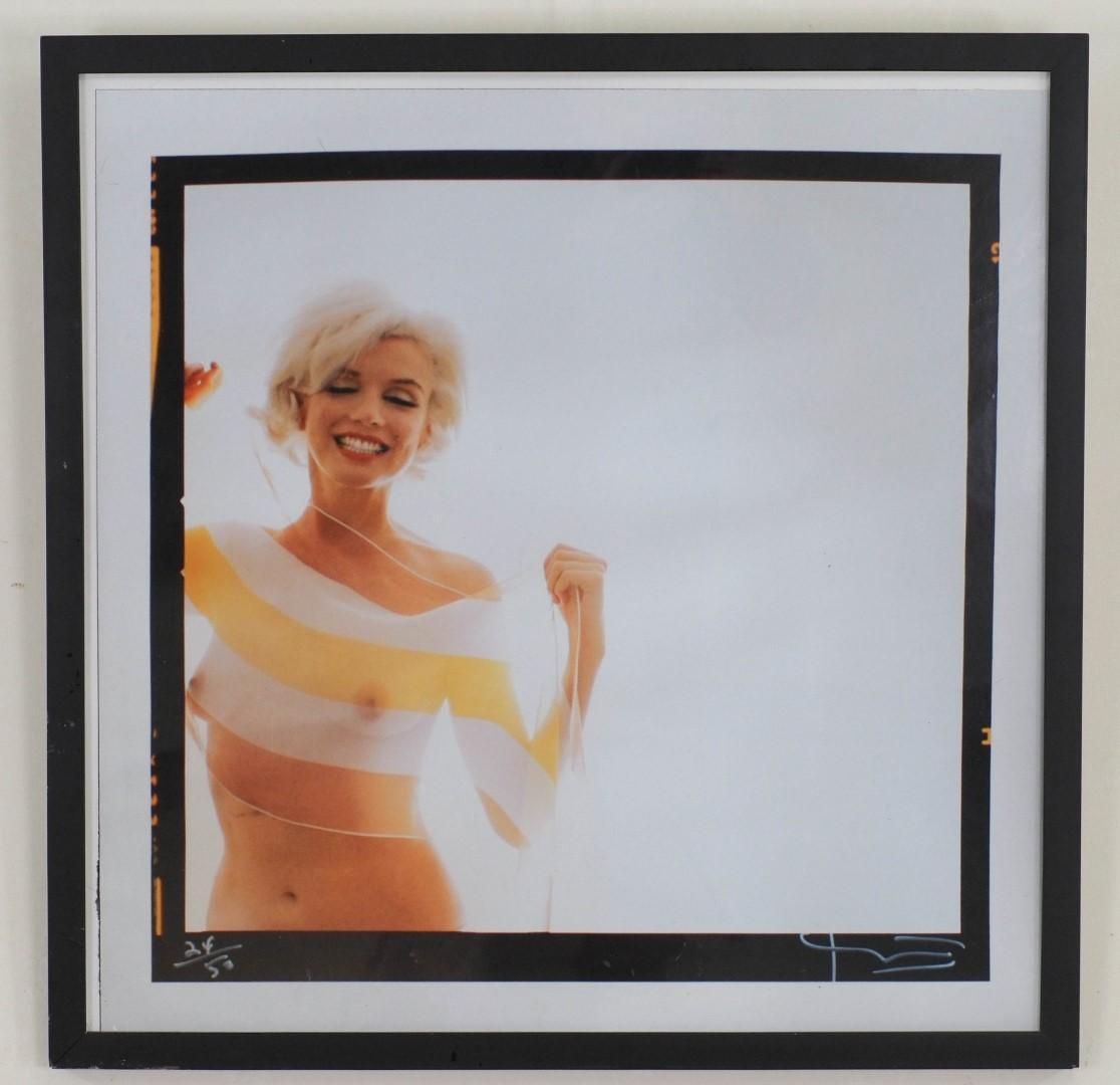 Woman smiling, wearing a striped top. Portrait inside a black framed border.