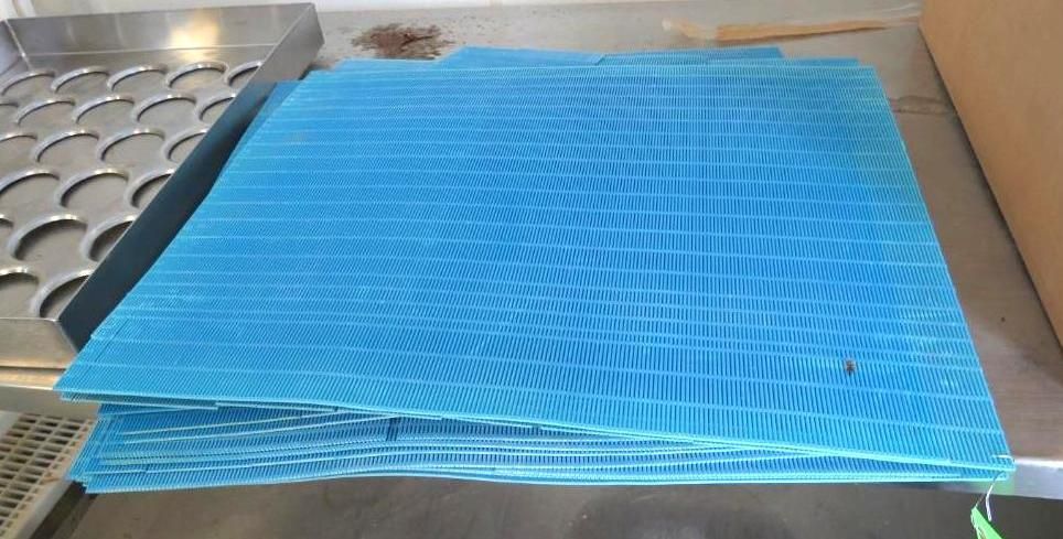 Stack of blue, grid-patterned plastic sheets.