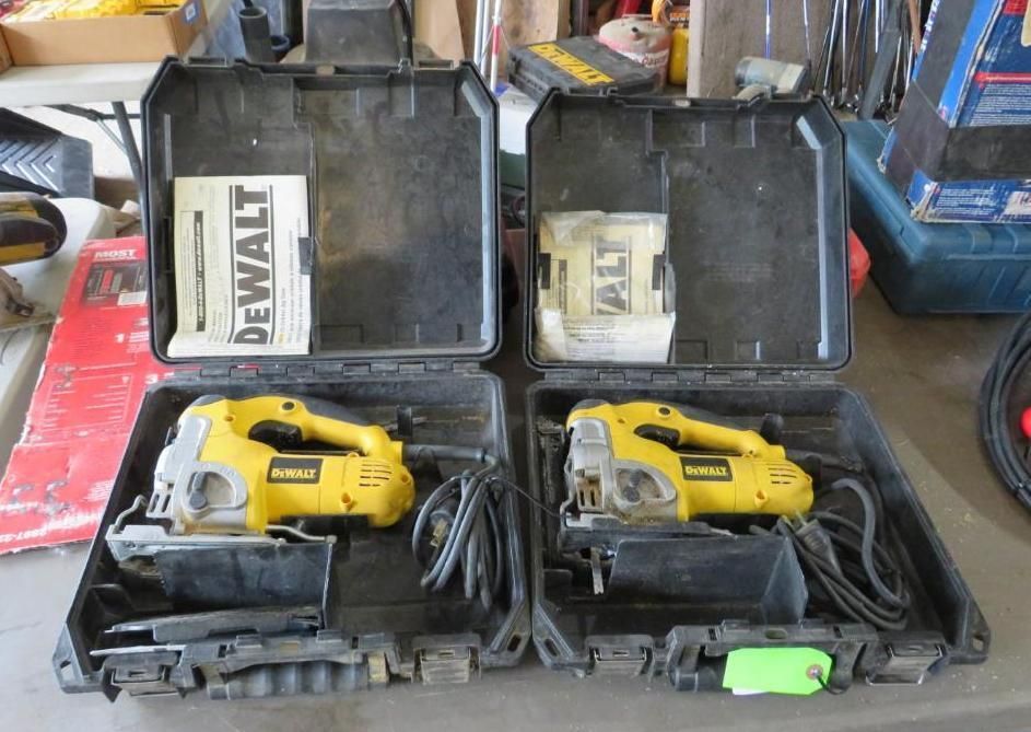 Two yellow and black DeWalt jigsaw tools in open black cases, with manuals.