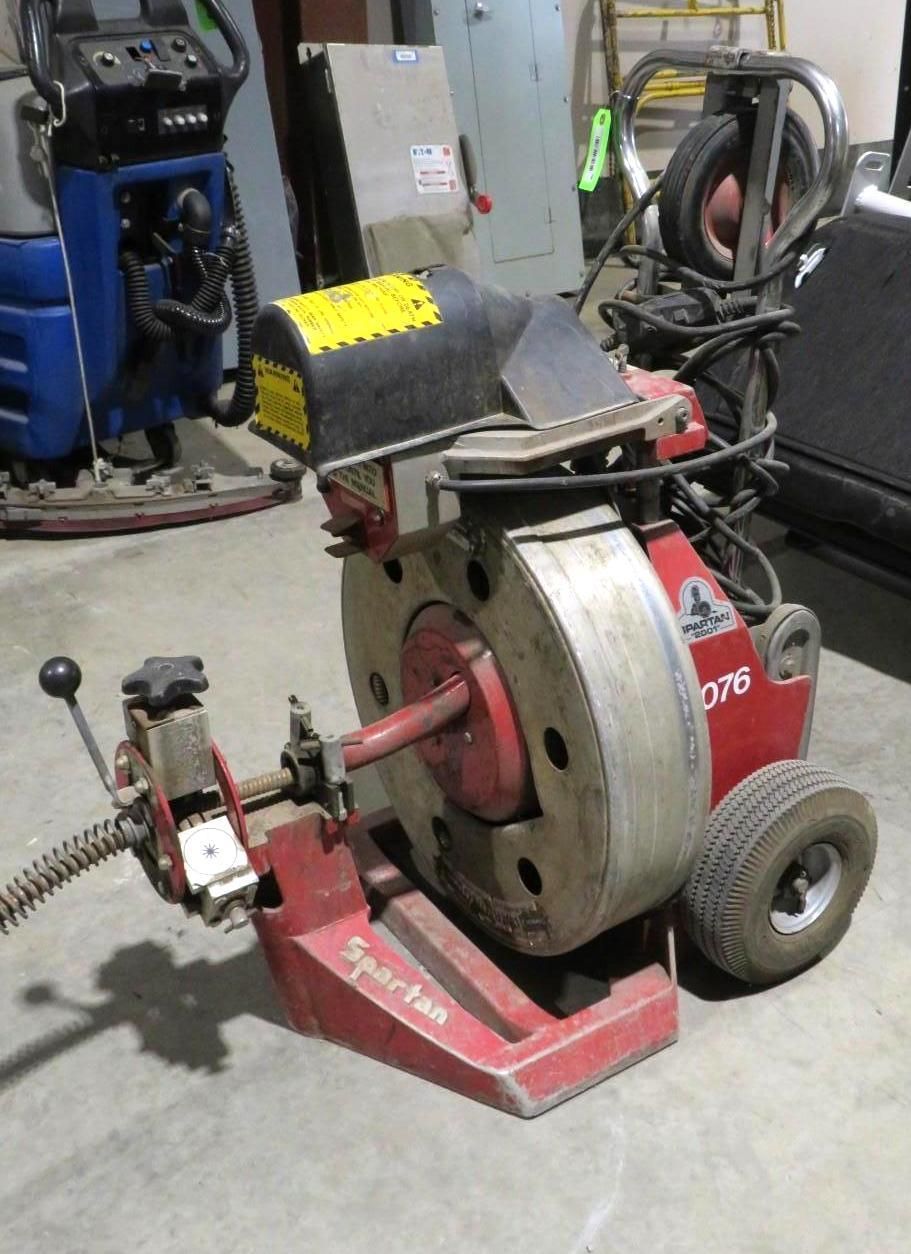 Red and silver Spartan drain cleaning machine with coiled cable.