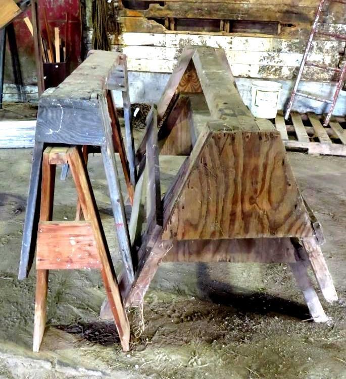 Two wooden sawhorses in a workshop.