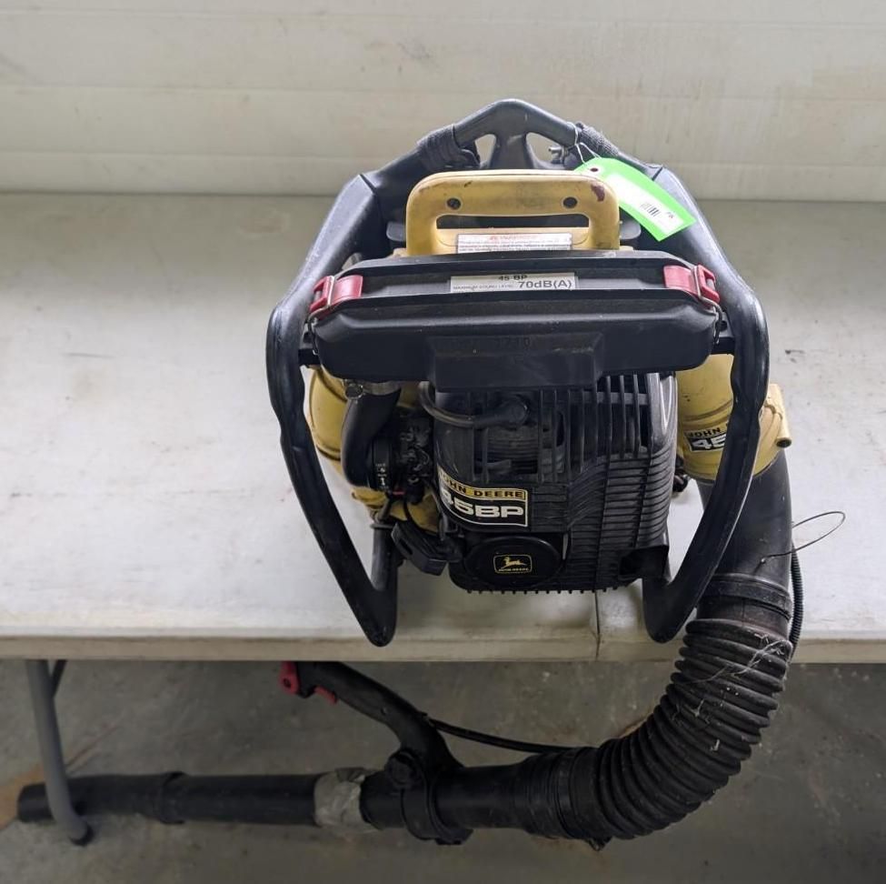 Yellow and black John Deere backpack leaf blower on a table.