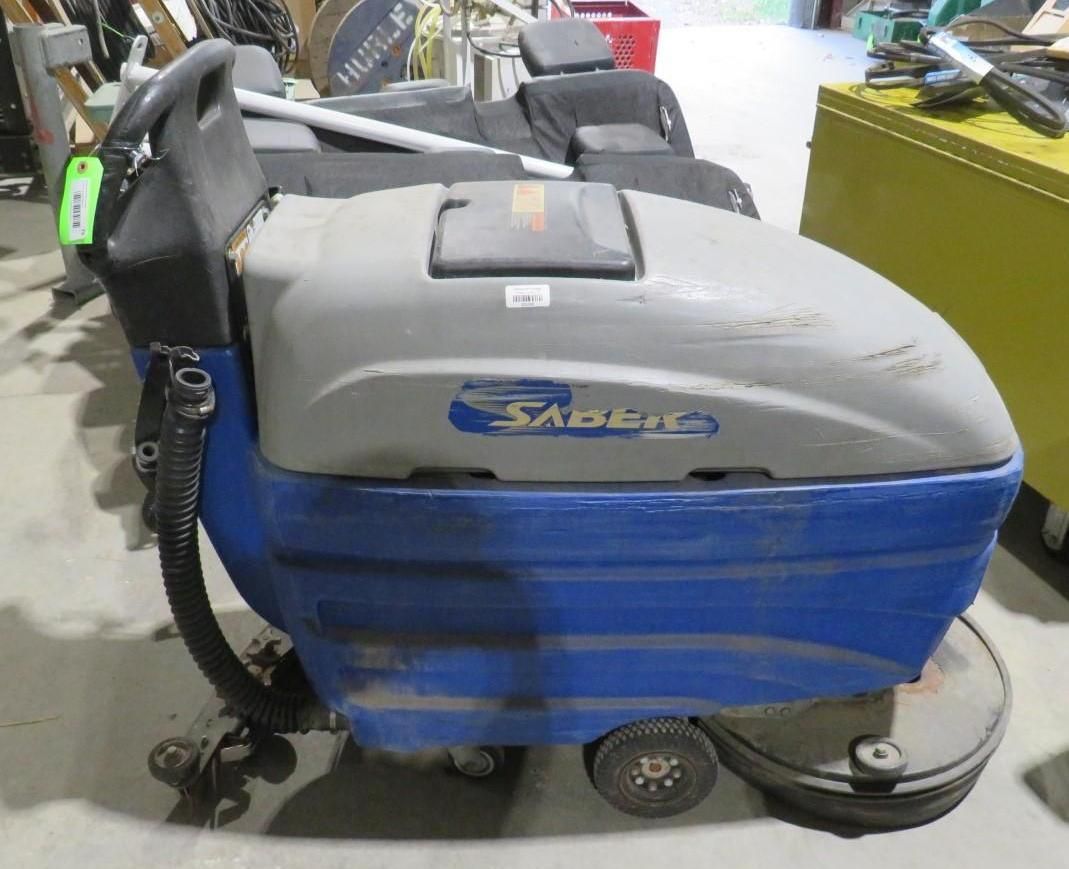 Blue and gray Saber floor scrubber machine on wheels.