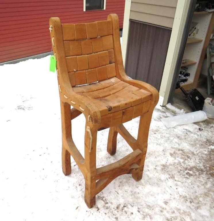 Wooden bar stool with woven seat and back, outside on snow.