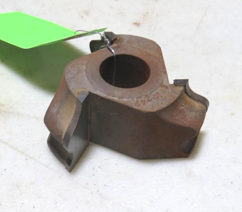Metal milling cutter with a circular center hole. Green tag is attached.