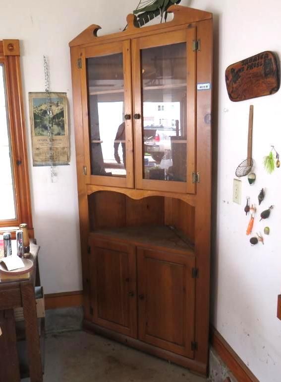 Corner cabinet with glass doors and lower solid doors.