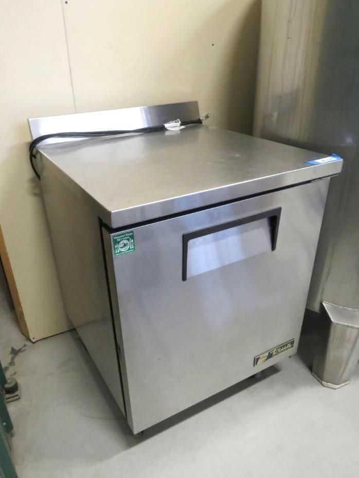 Stainless steel commercial refrigerator in a room.