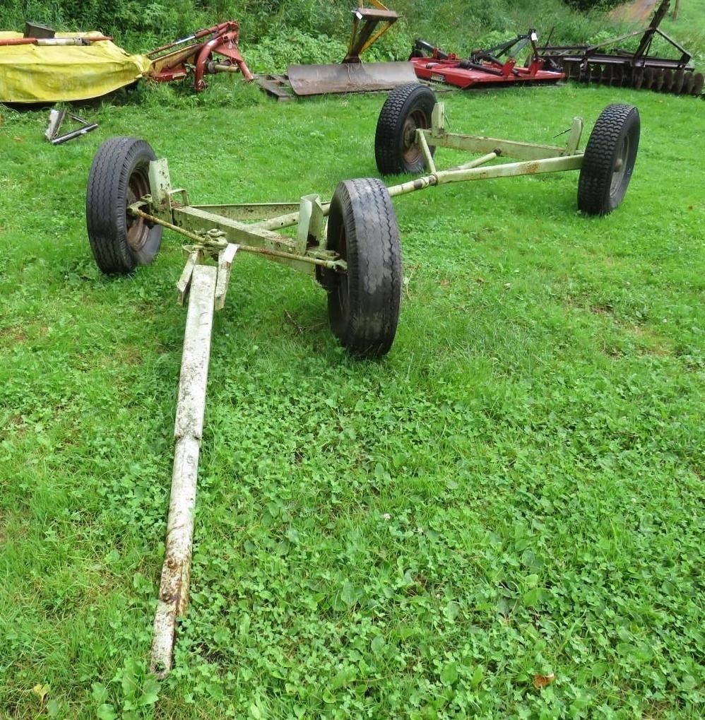 Tandem wheel trailer on green grass, with white hitch arm.