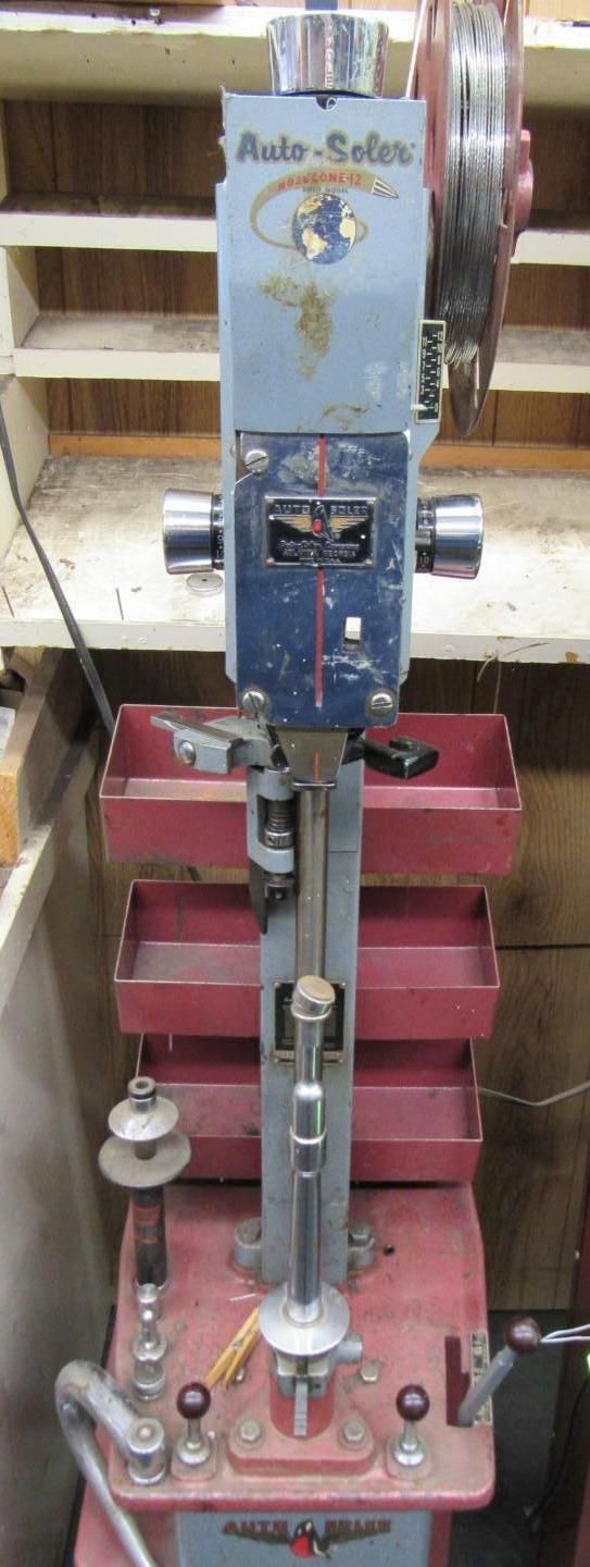 A vintage, red and gray Auto-Soler machine, a tool for manufacturing or repairing.