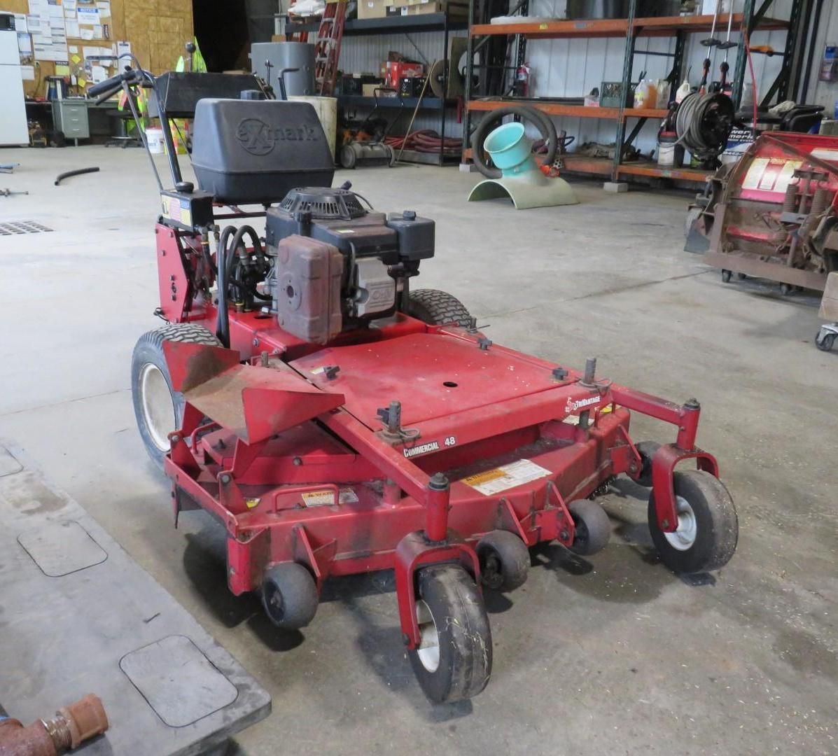 Red commercial lawn mower in a garage.