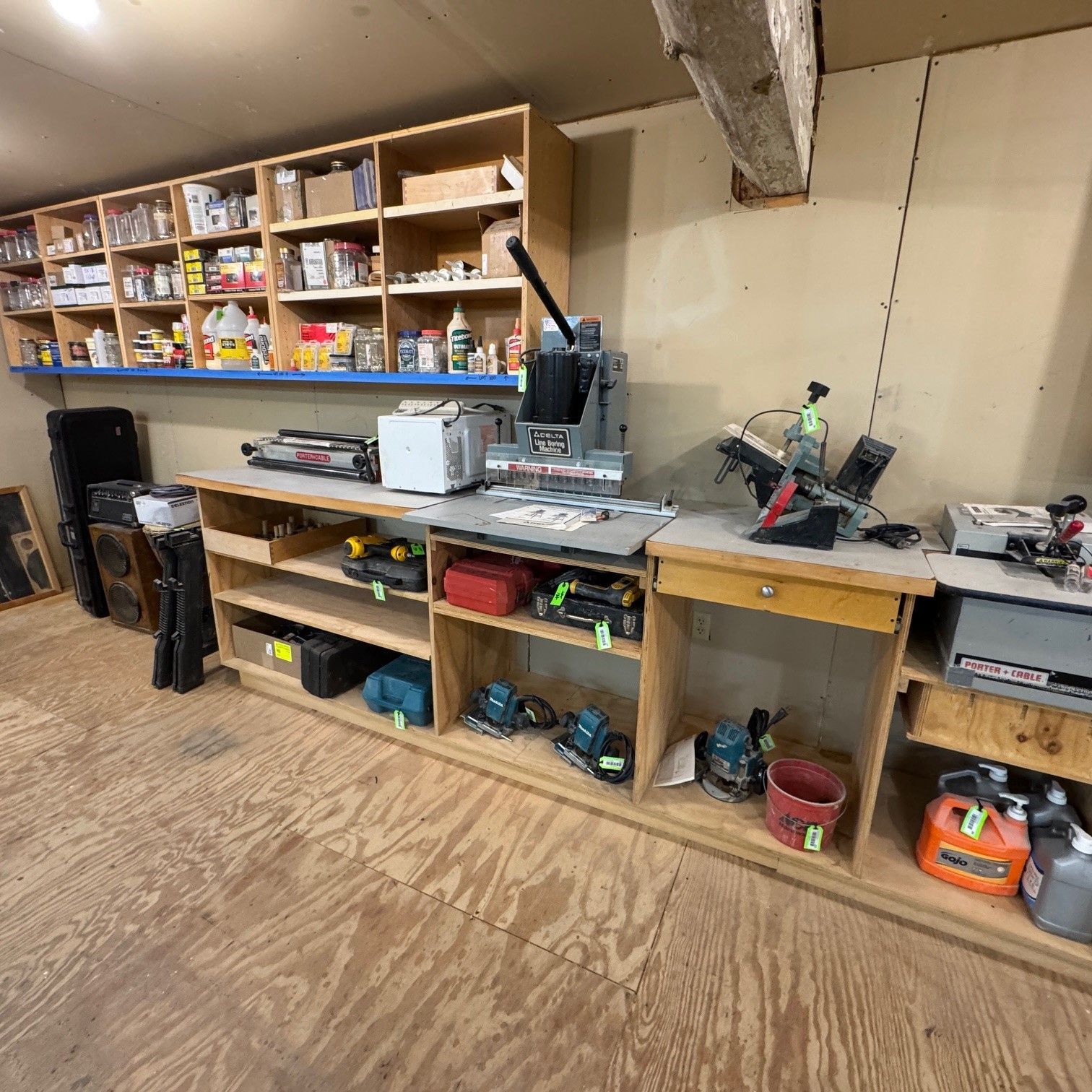 Workshop with wooden shelves of supplies, workbench, and power tools.