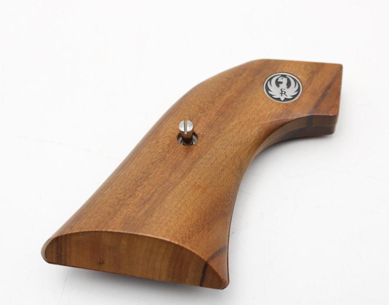 Wooden pistol grip with a metal screw and emblem on a white background
