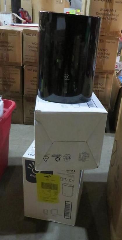 Black cylindrical object on two stacked white boxes; warehouse setting.