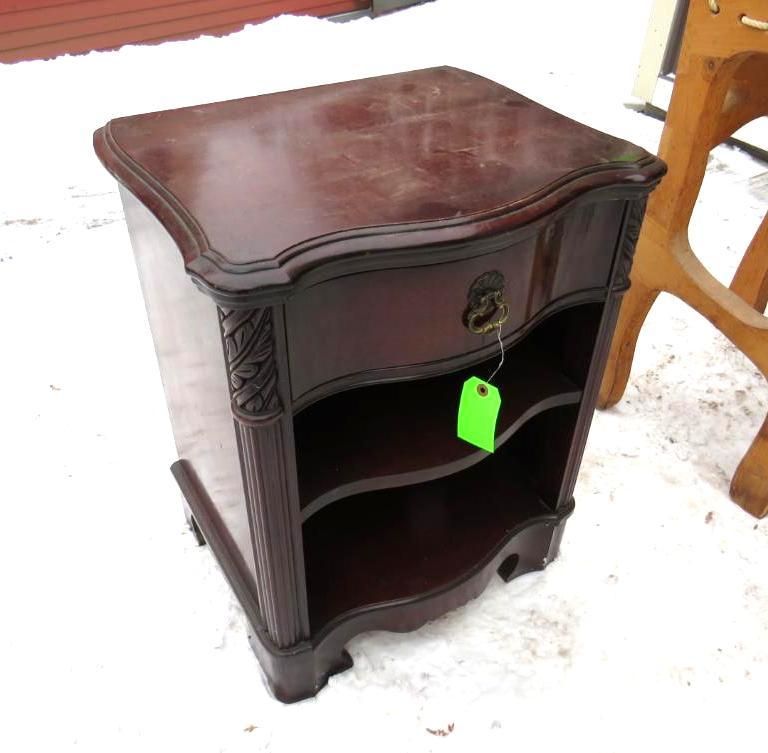 Dark wood nightstand with drawer and shelves, outdoors on snow.