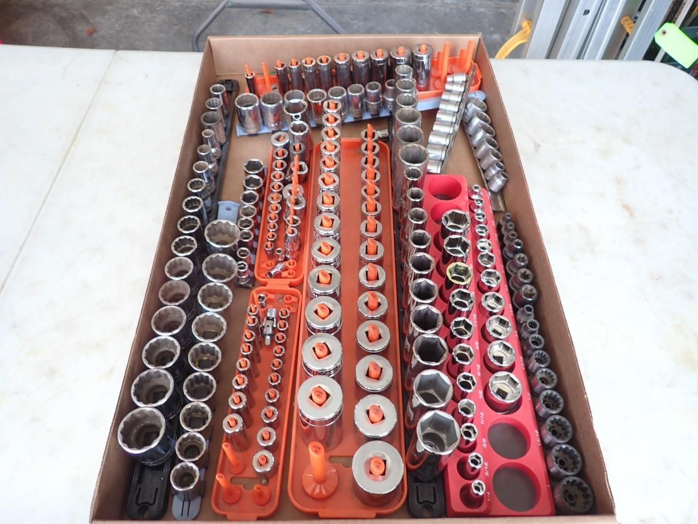Organized trays of socket wrenches and tool bits in red and orange holders on a workbench