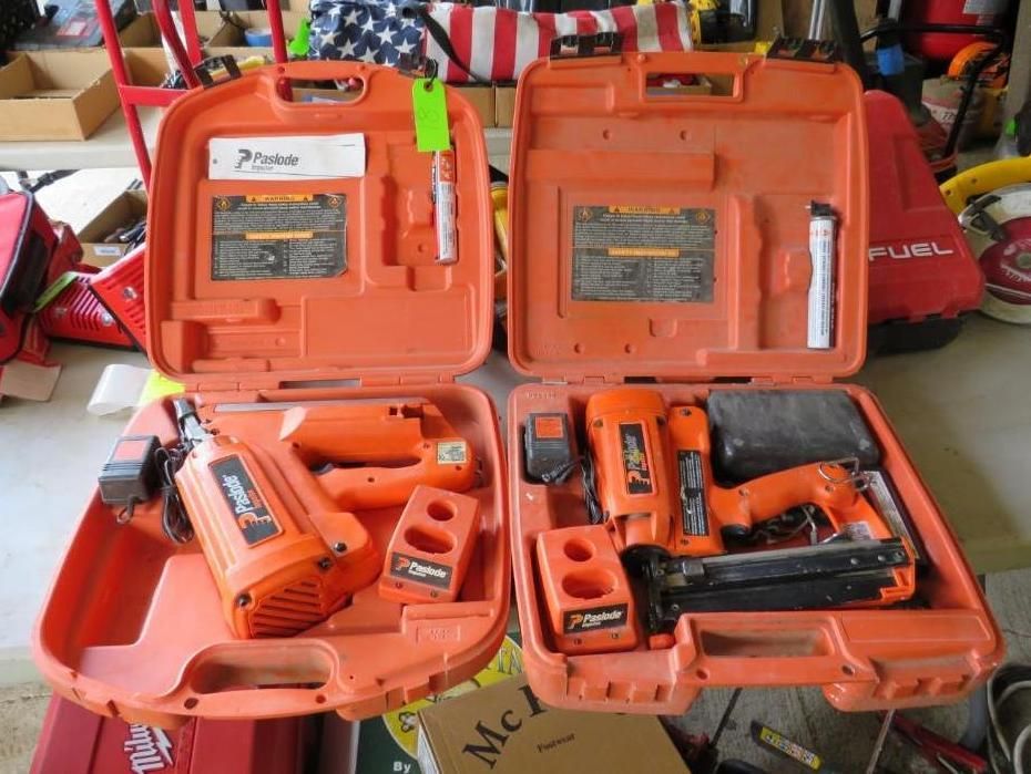 Two open orange tool cases with cordless nail guns, batteries, and accessories.