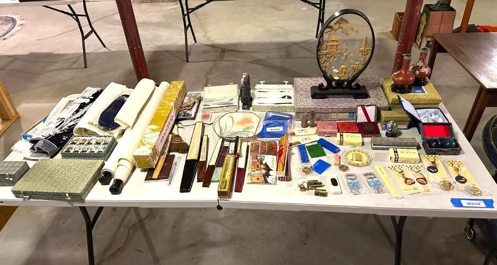 Table of various items for sale, including jewelry, decor, and other small goods.