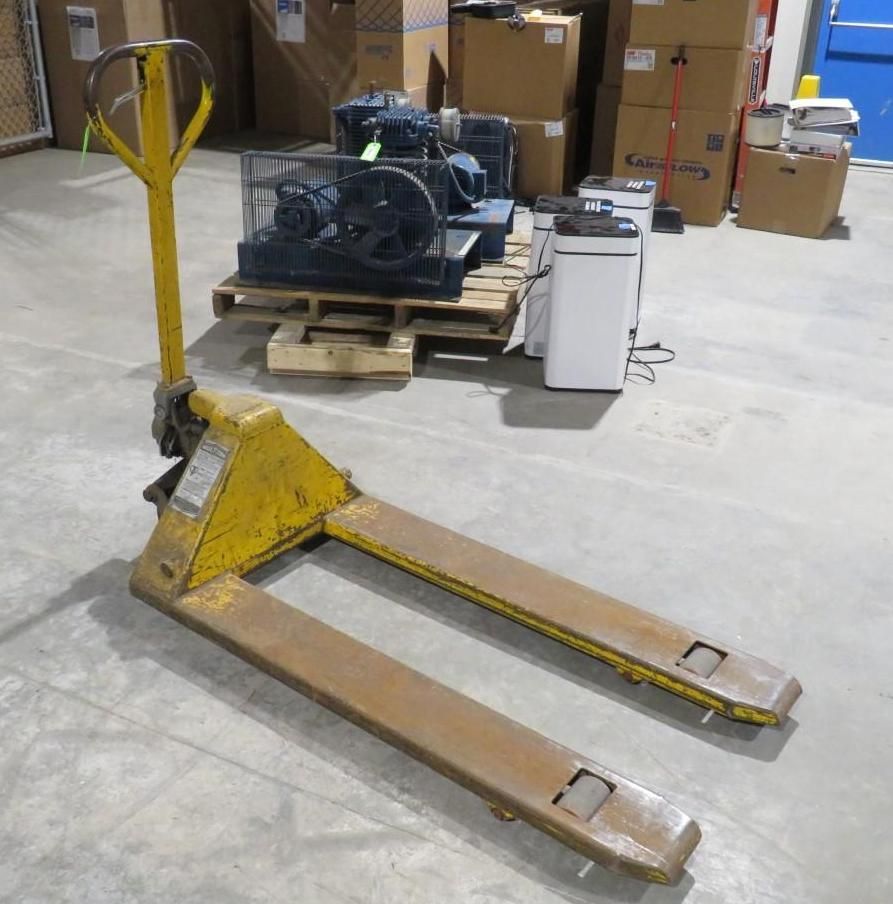Yellow pallet jack in a warehouse.