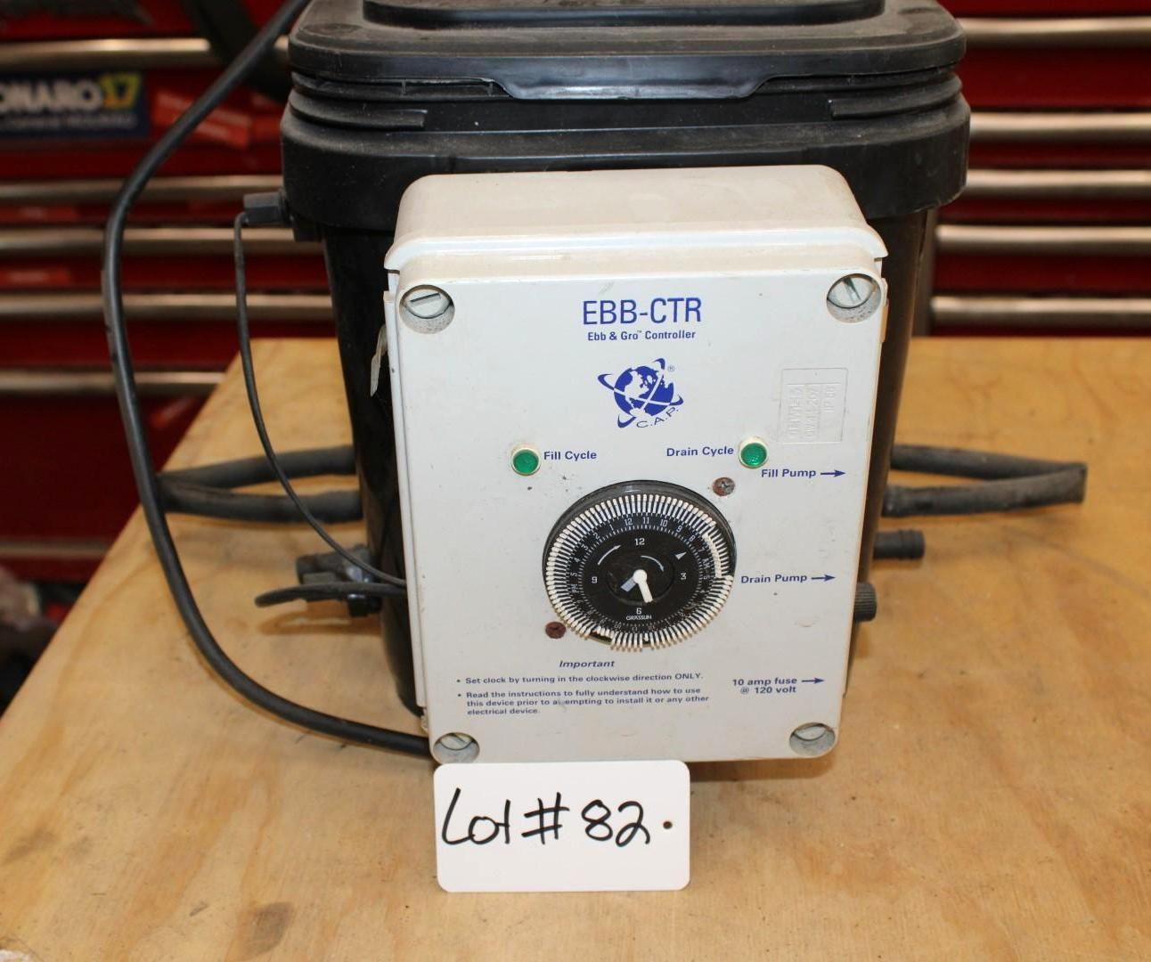 Control panel attached to black bucket with a timer dial and indicator lights.
