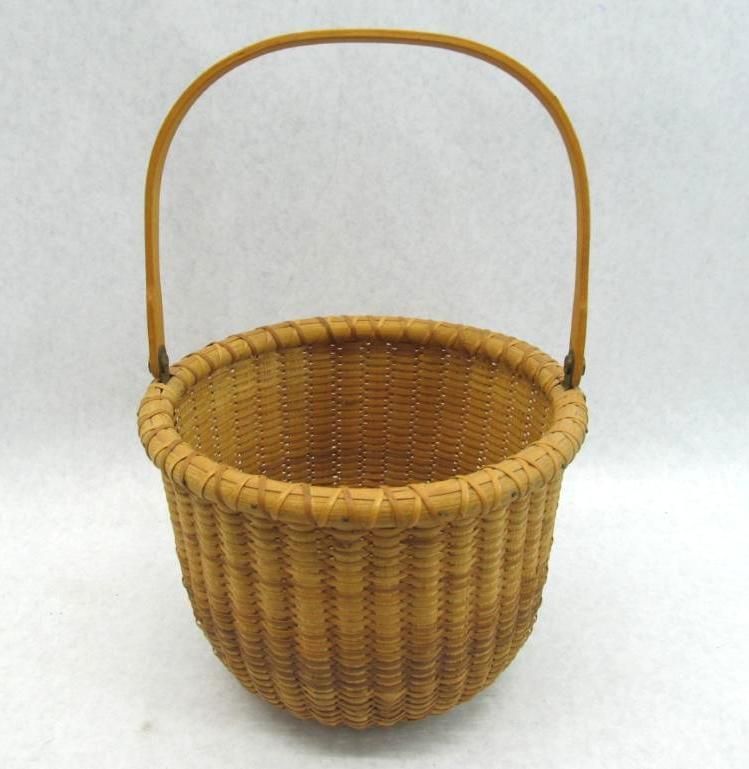 Woven basket with a curved handle, beige color.