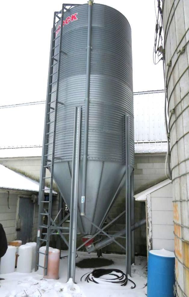 Metal grain silo on legs, with ladder.