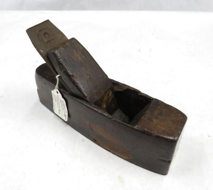 Wooden hand plane, brown, with blade access opening.