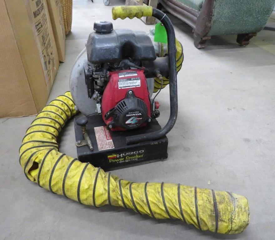 Red and black portable Honda engine with yellow flexible hose on a gray concrete floor.