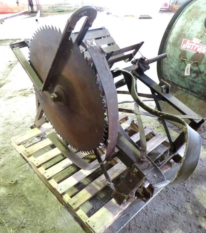 A circular saw mounted on a metal frame, resting on a wooden pallet.