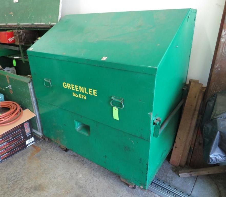 Green Greenlee tool cabinet with slanted lid, handles, and wheels; indoors.