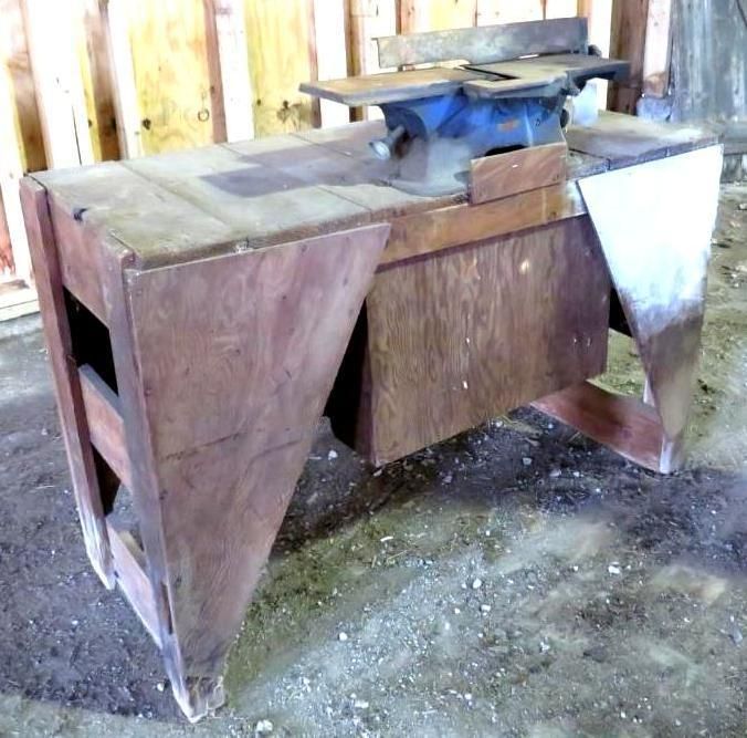 Woodworking jointer table, brown wood, in a workshop setting.